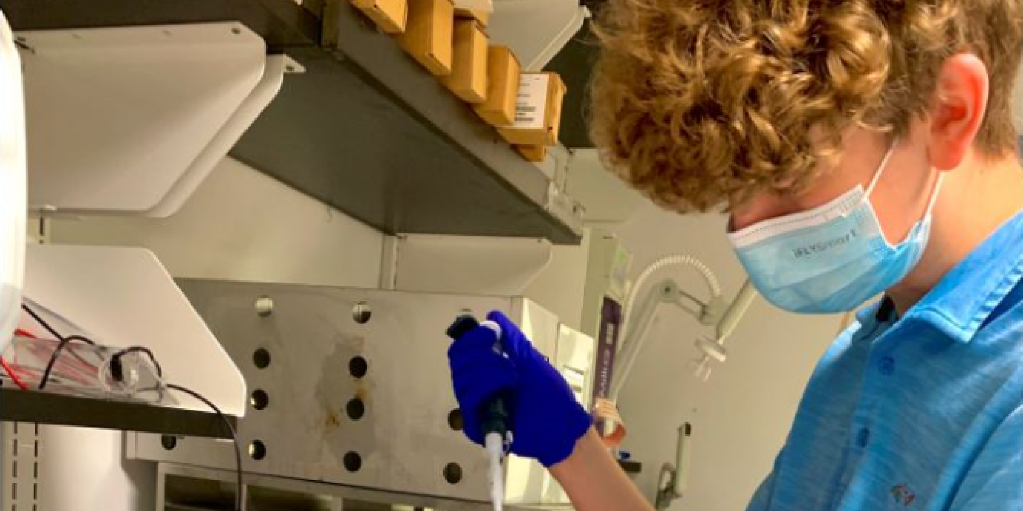 A student who received WEP funding works with a pipette at a lab