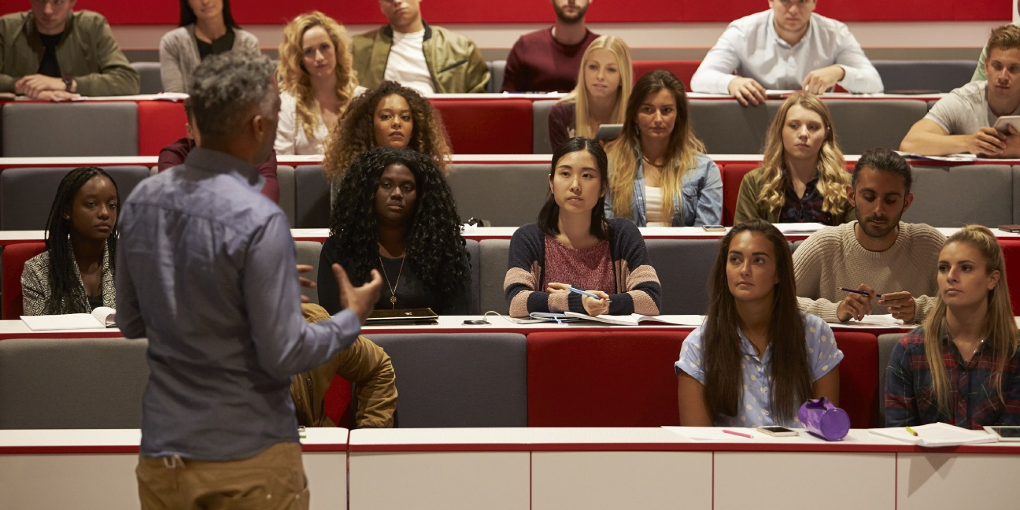 Students listening to professor in classroom.