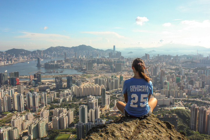 Student sitting on cliff staring into distance