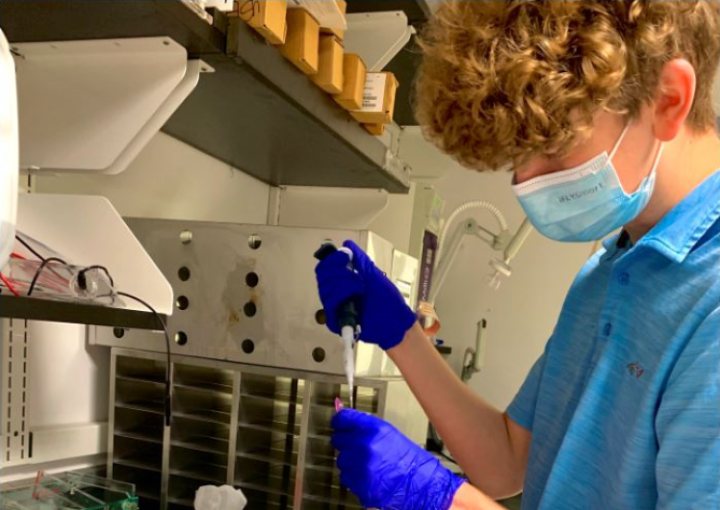 A student who received WEP funding works with a pipette at a lab