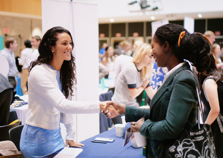 Female recruiter shakes the hand of a Columbia female student at a career fair.