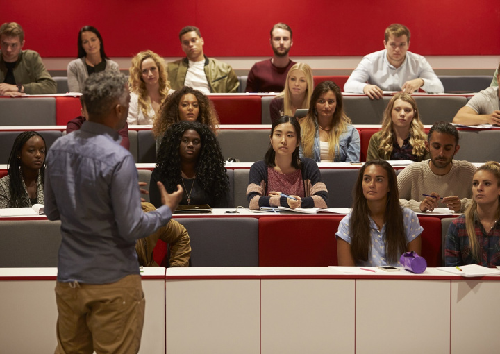 Students listening to professor in classroom.